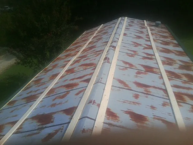Rusted metal roof panels with new wood purlins before replacement — Storm Damage Roof Repair in Walcott by Roofing Brothers