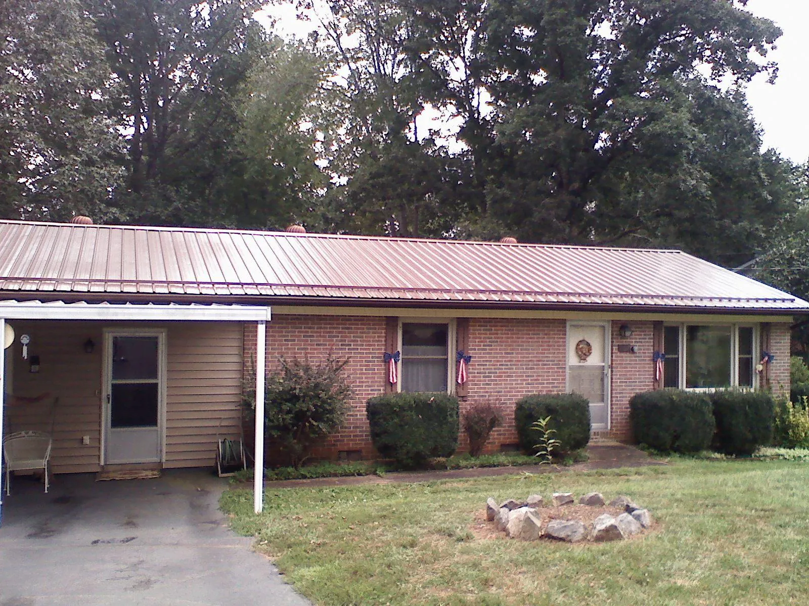 Bronze metal roof and carport on a brick ranch home — Roof Repair work by our crew in Walcott